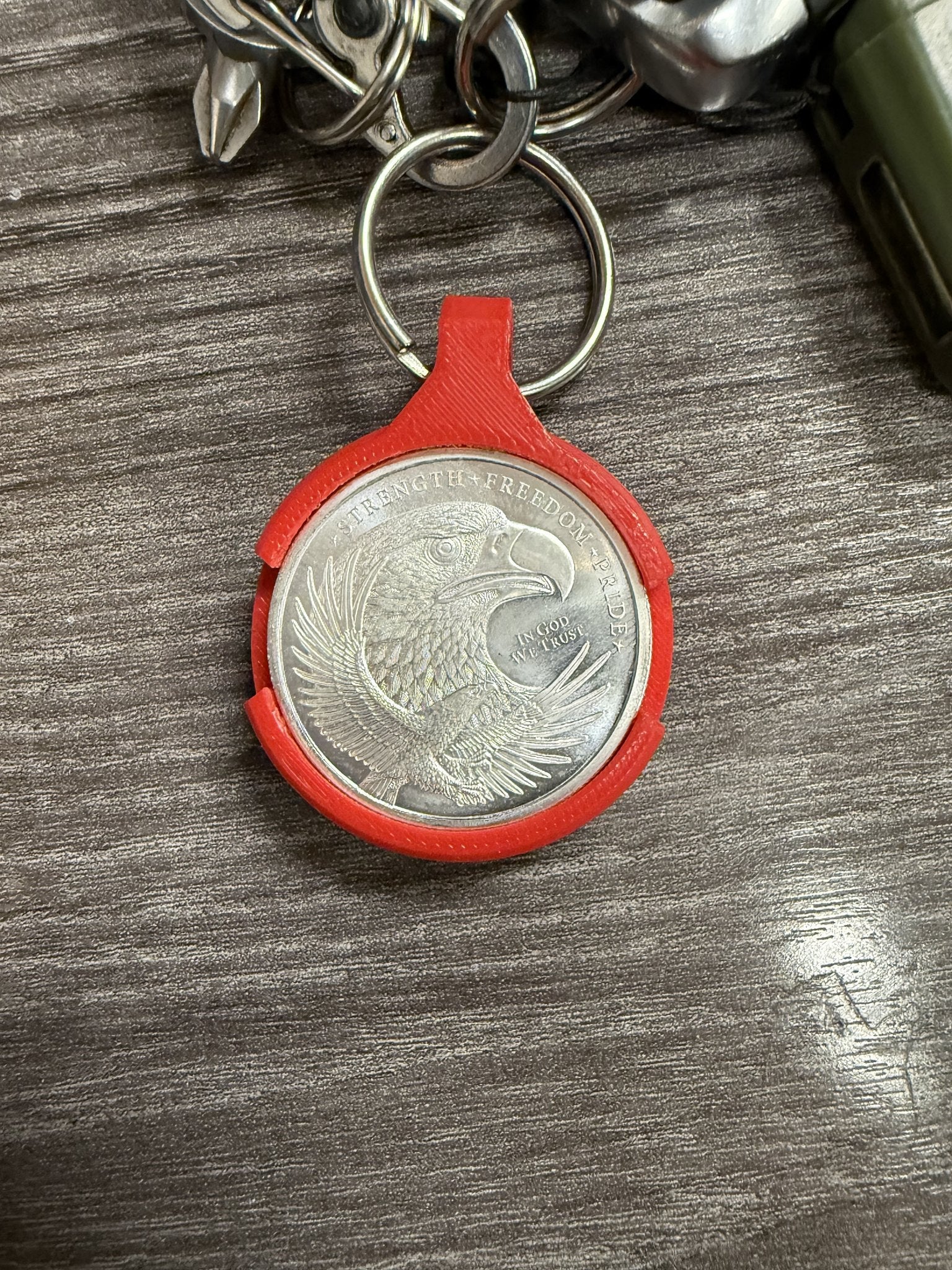 Coin AirTag Hiding Keychain attached to a keyring with house keys
